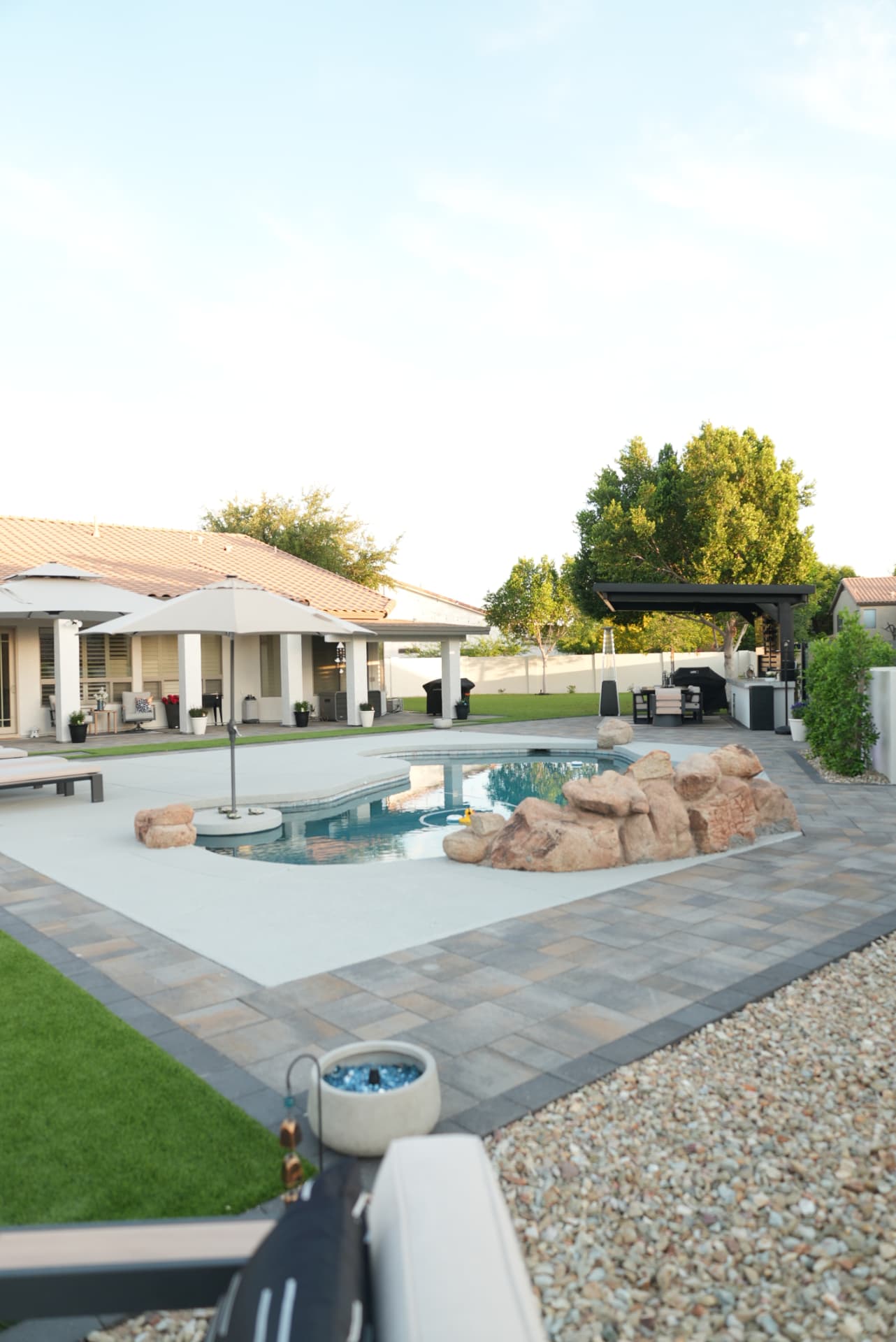 Luxury Arizona backyard at sunset with pool, paver decking and custom pavilion