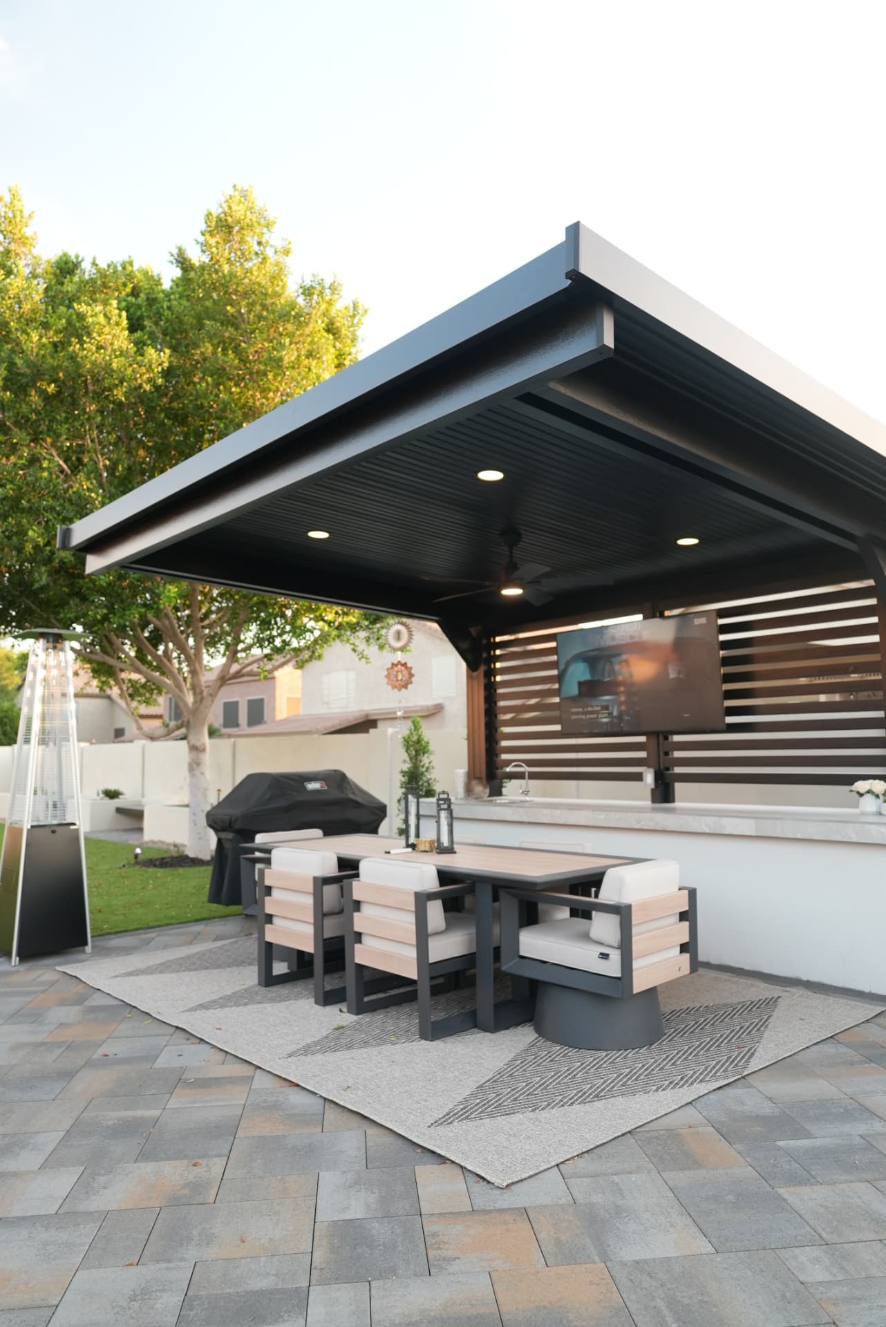 Custom charcoal pavilion with wood slat feature wall and outdoor dining